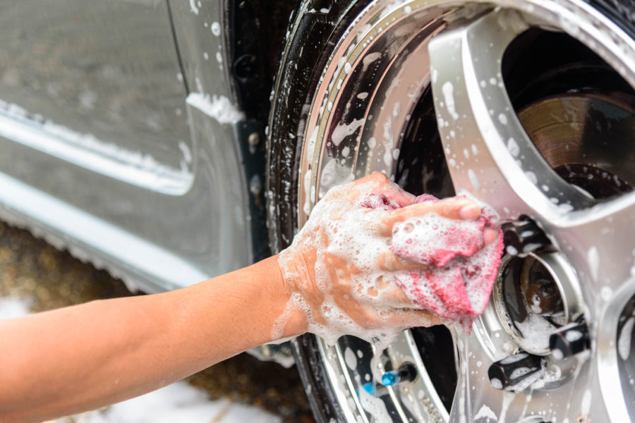 the man wash the wheel of car